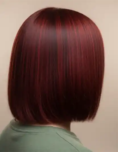 Person with straight, sleek, shoulder-length dark red hair, shown from the back, wearing a green top.