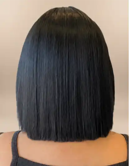Person with straight, shoulder-length black hair viewed from the back, wearing a sleeveless dark top.